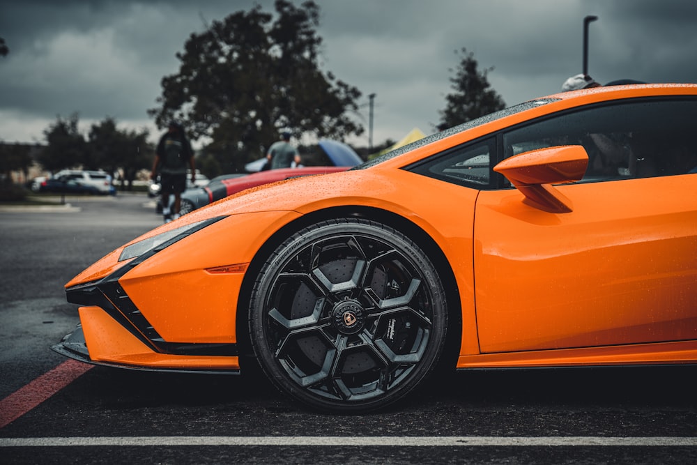 an orange sports car parked in a parking lot