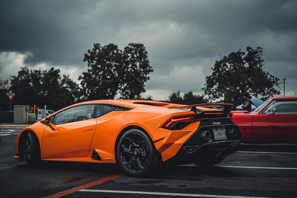 an orange sports car parked in a parking lot