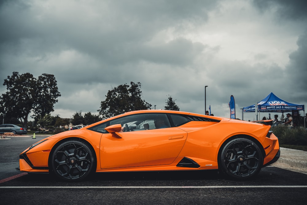 an orange sports car parked in a parking lot