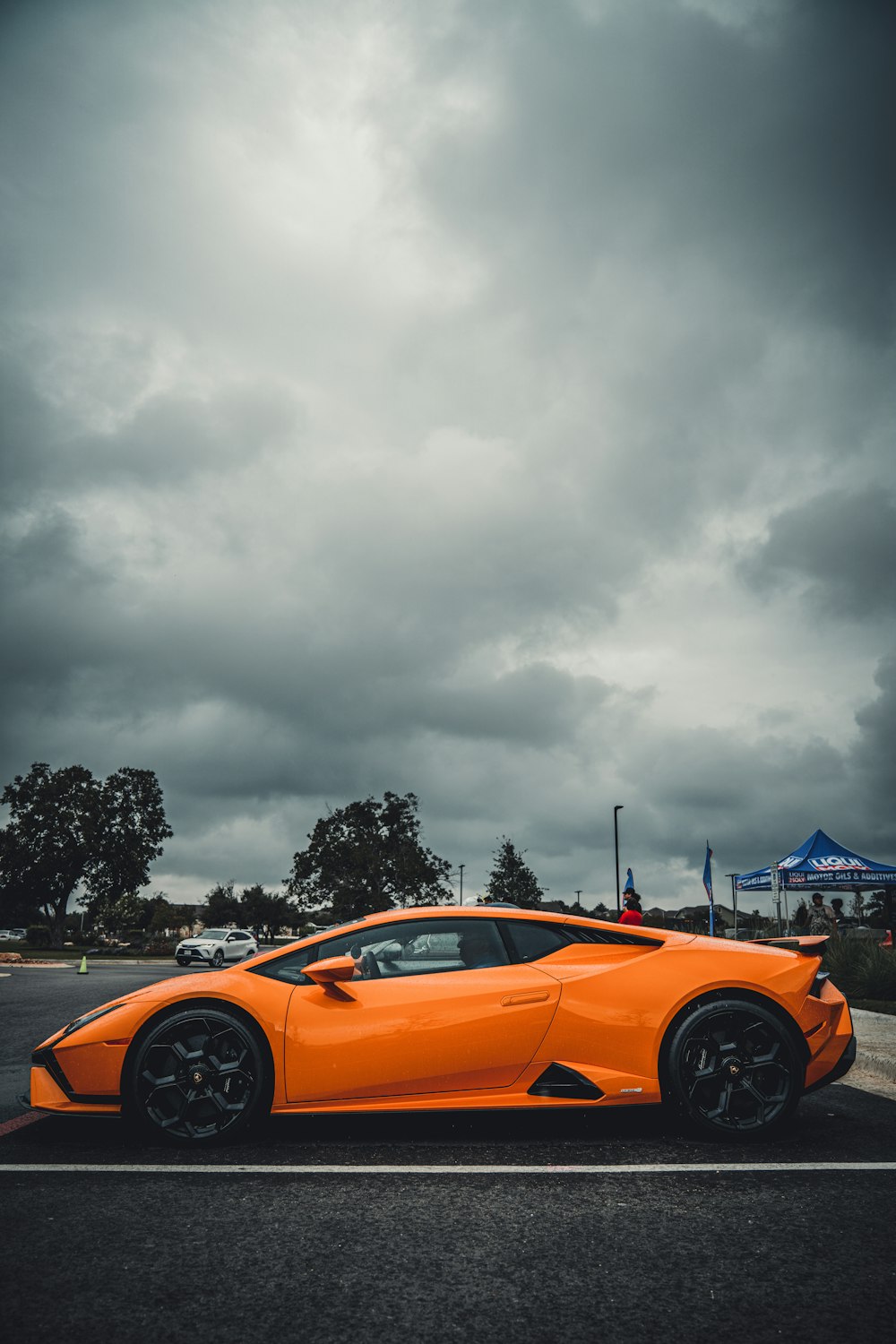 an orange sports car parked in a parking lot