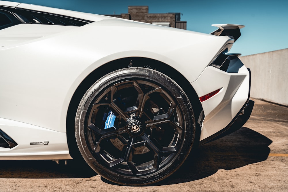 a white sports car parked in a parking lot