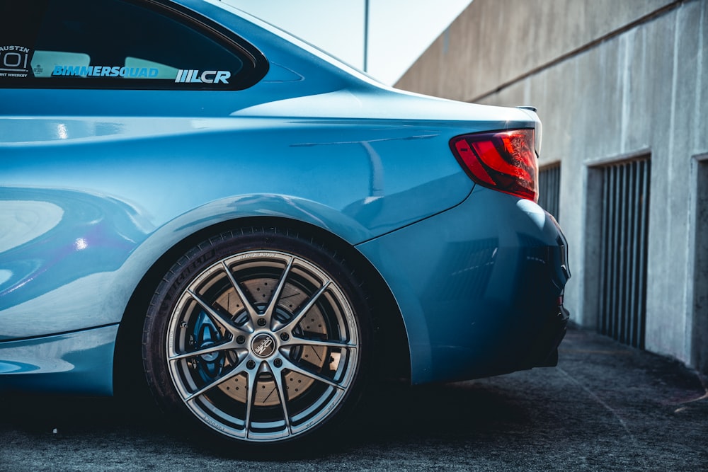 a blue car parked in a parking lot next to a building