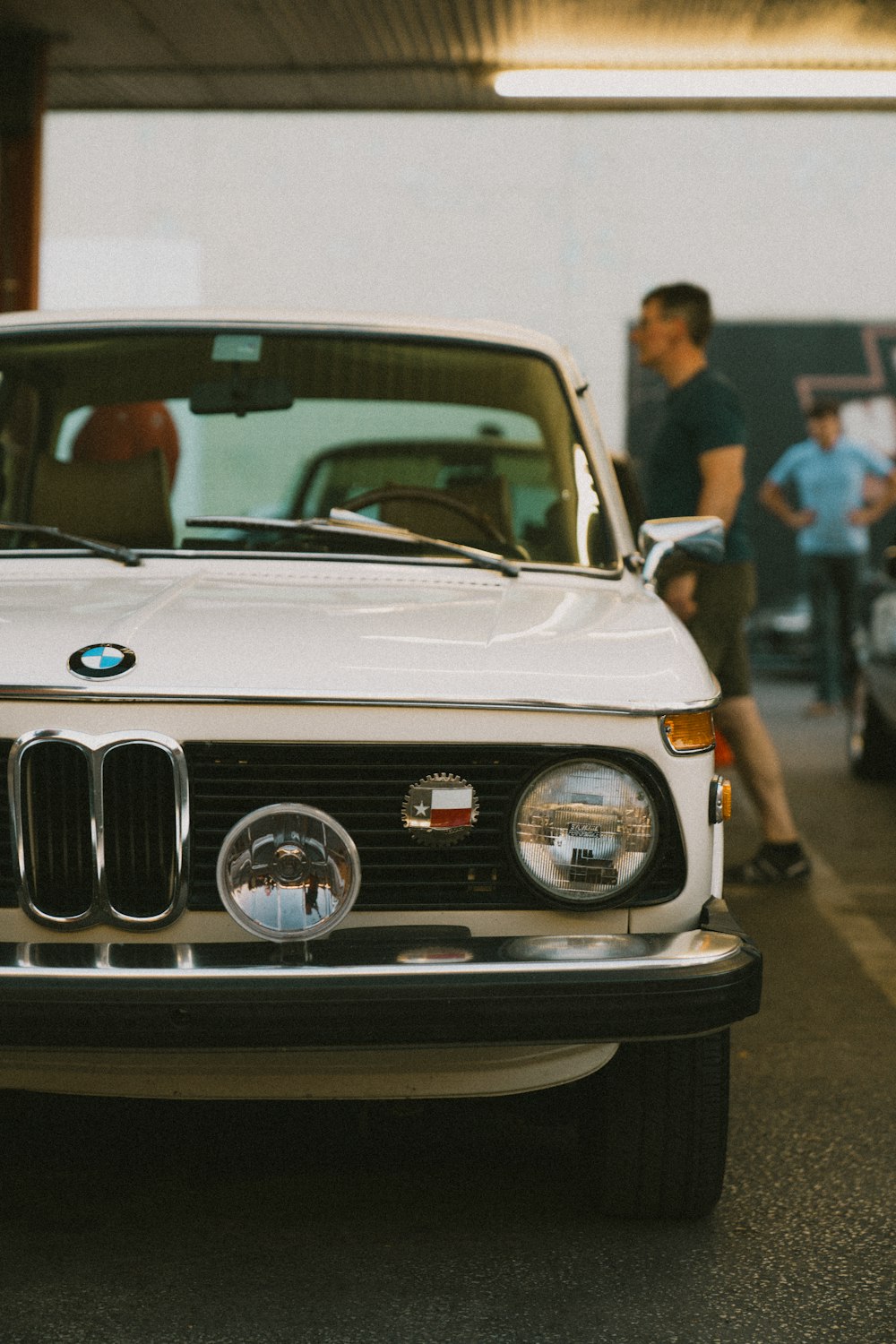 a white bmw is parked in a garage