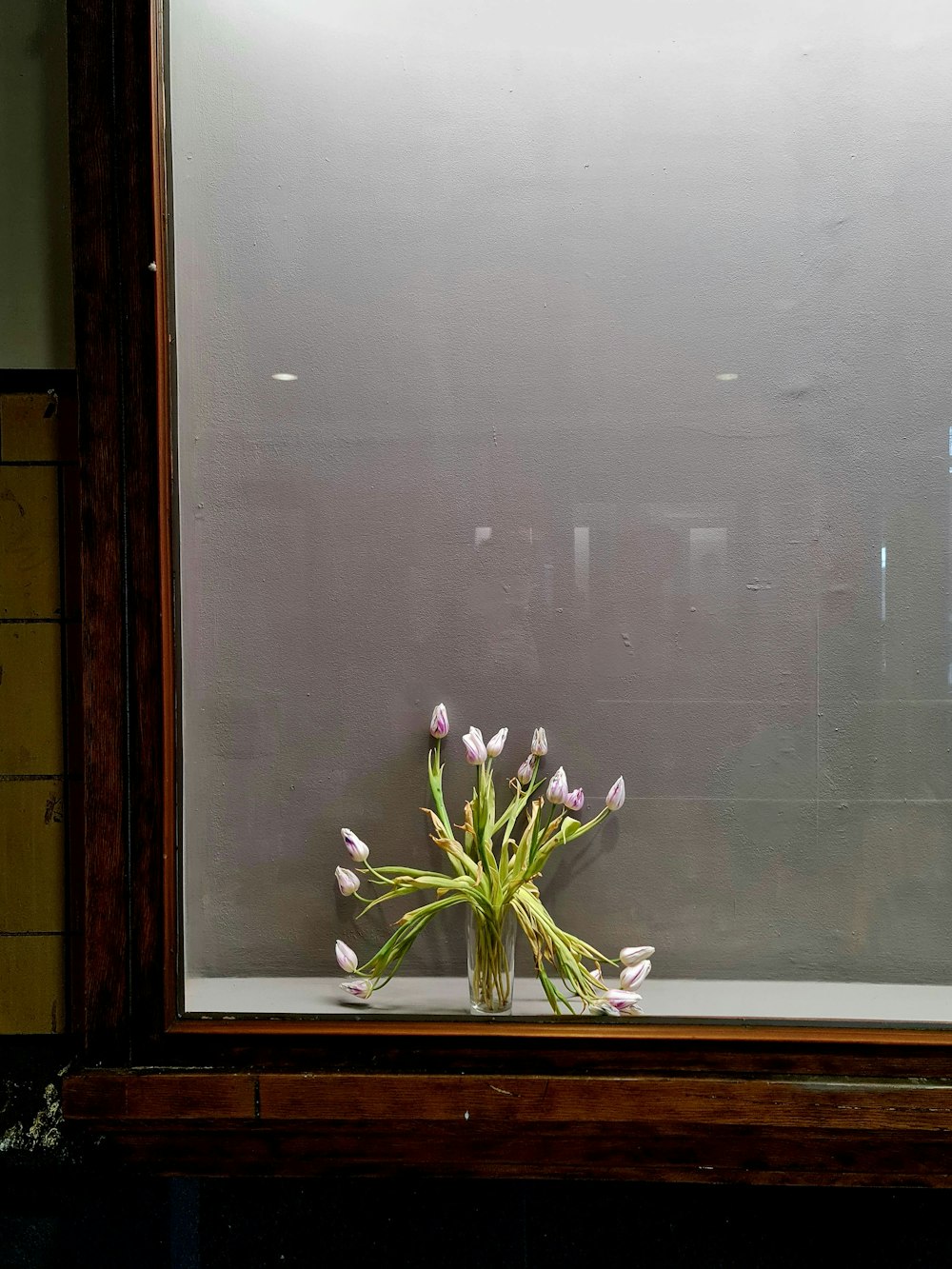 a vase filled with flowers sitting on top of a window sill