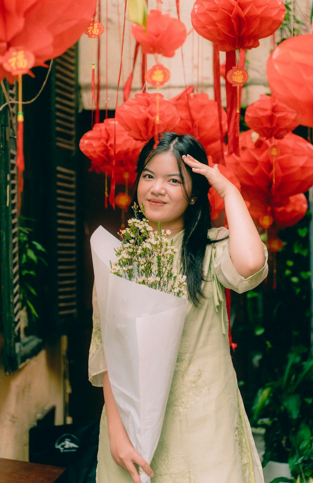 uma mulher segurando um ramo de flores de papel vermelho