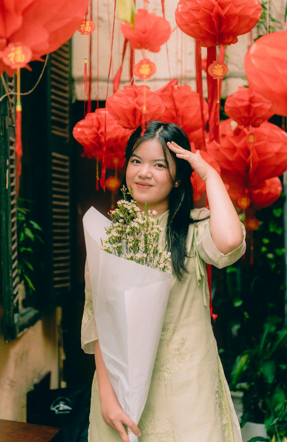 a woman holding a bunch of red paper flowers