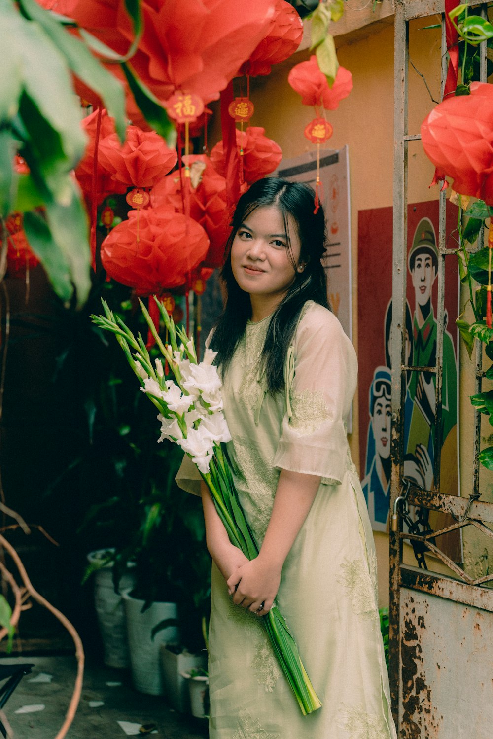 a woman in a green dress holding a bouquet of flowers