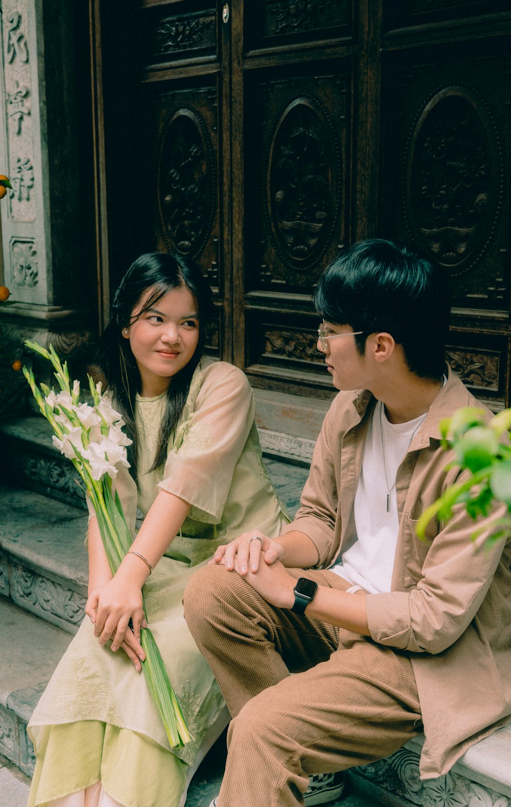 a man and a woman sitting on the steps of a building