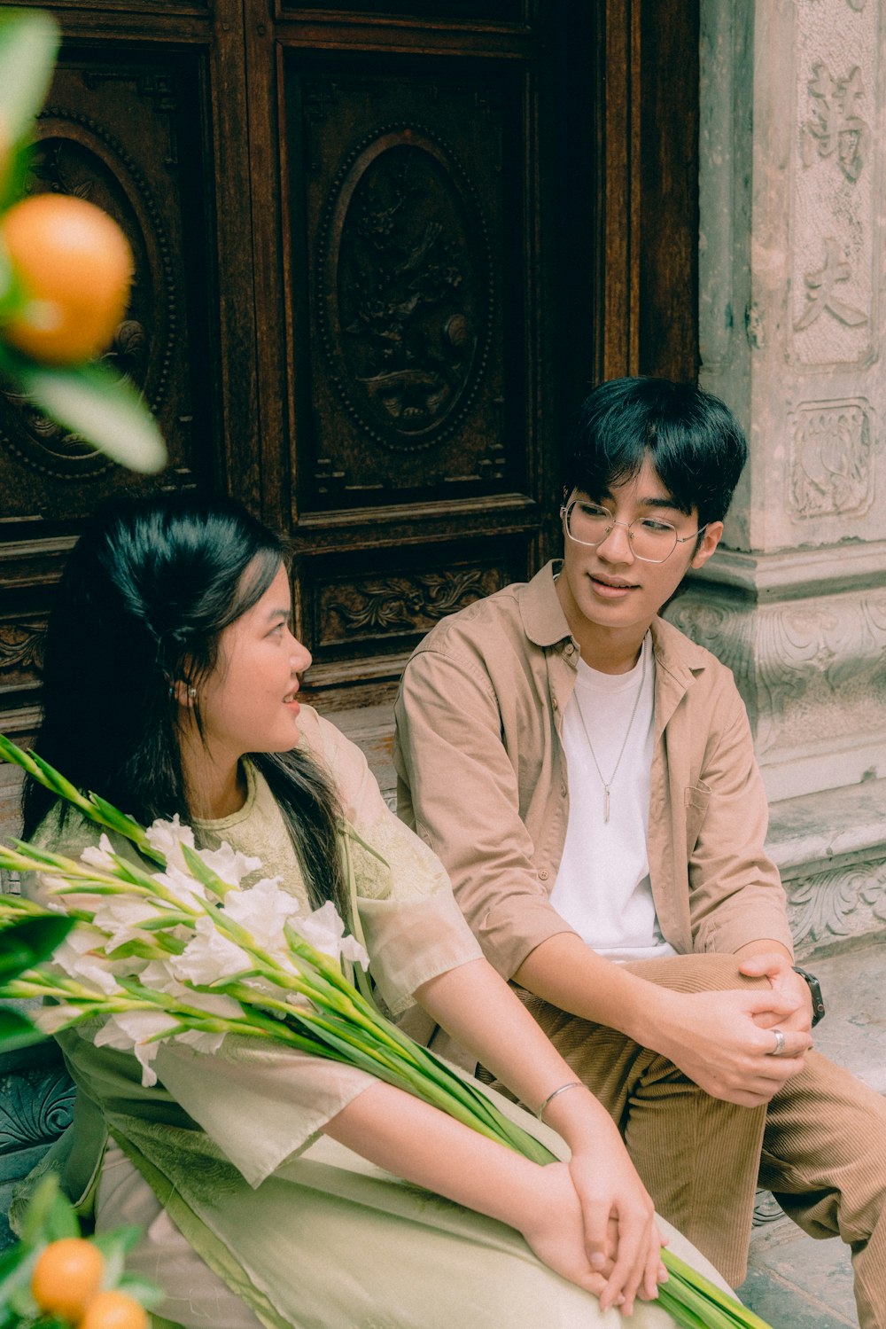 a man and a woman sitting on the ground next to each other