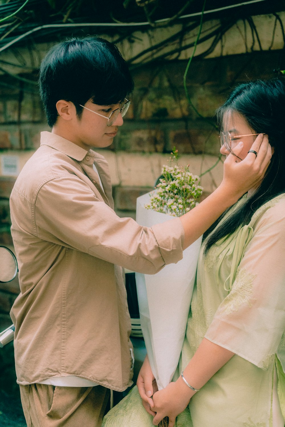 a man putting a flower pot on the back of a woman's head