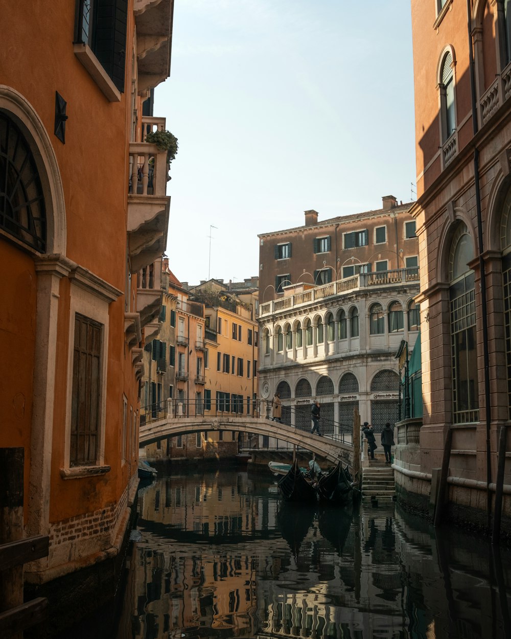 a canal in a city with buildings and a bridge