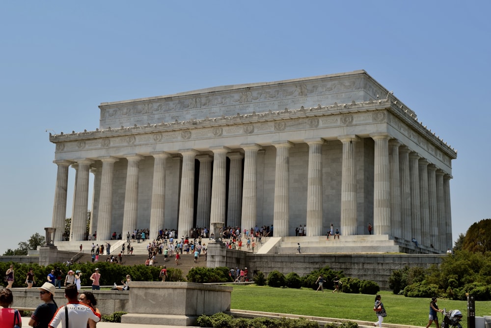 a group of people standing in front of the lincoln memorial