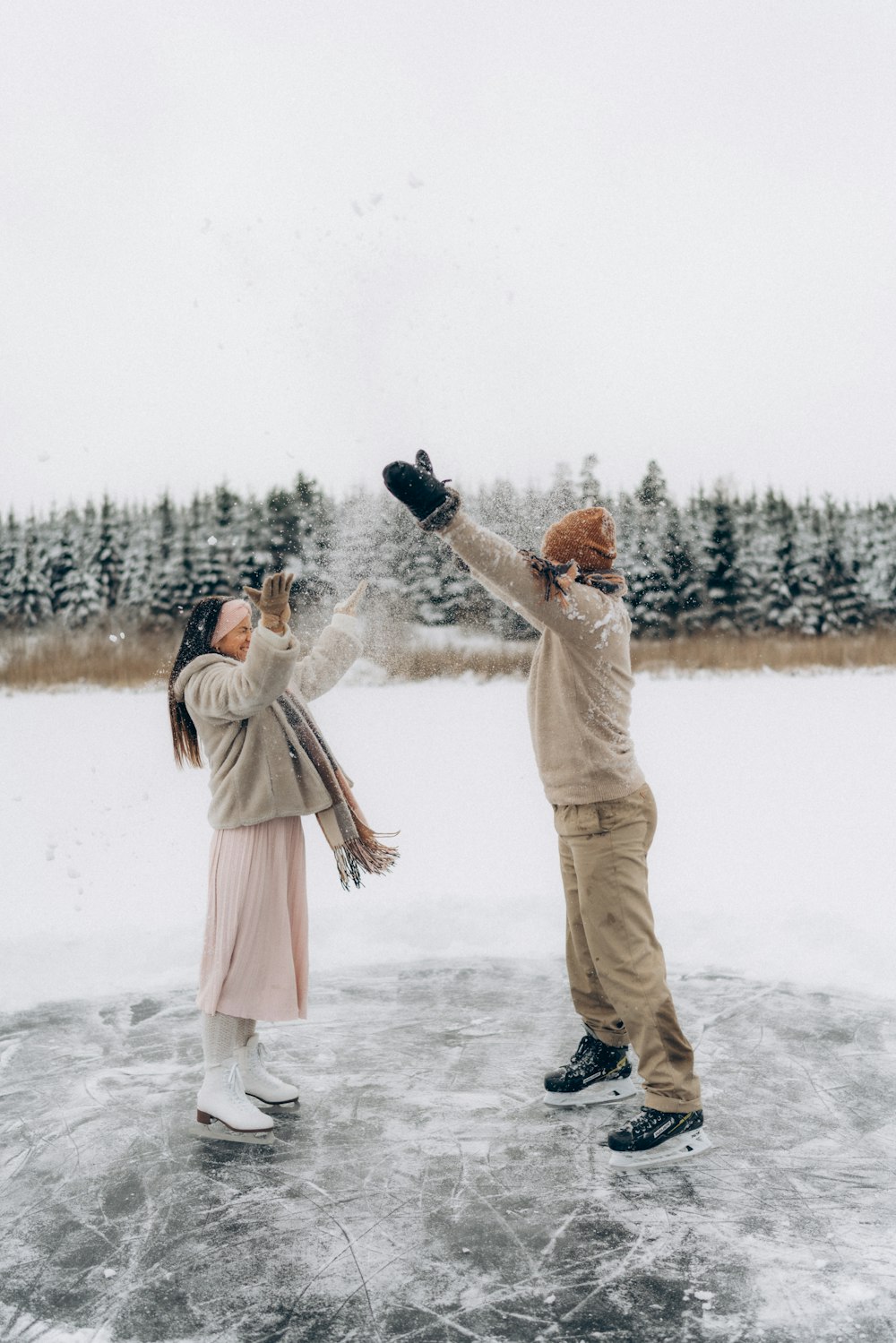 a couple of people standing on top of a frozen lake