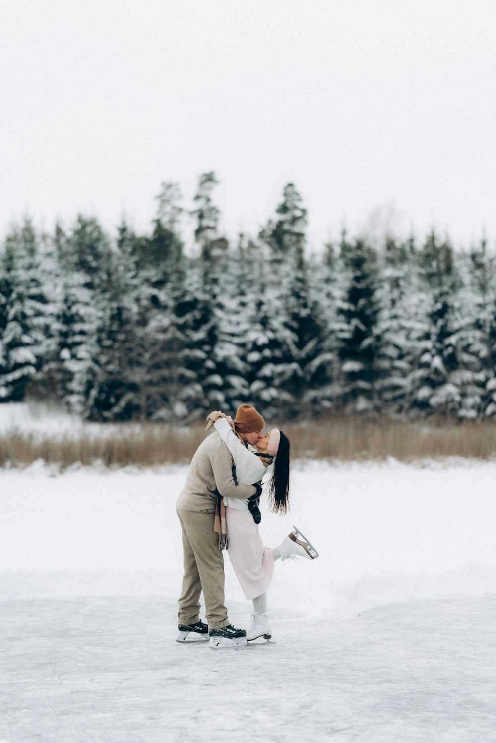 a man and woman kissing on a frozen lake