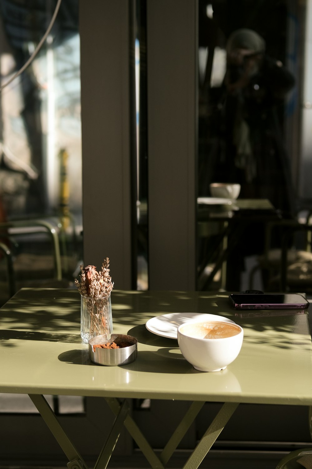 a green table with a white bowl of food on top of it