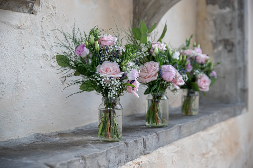 a row of vases filled with pink and white flowers