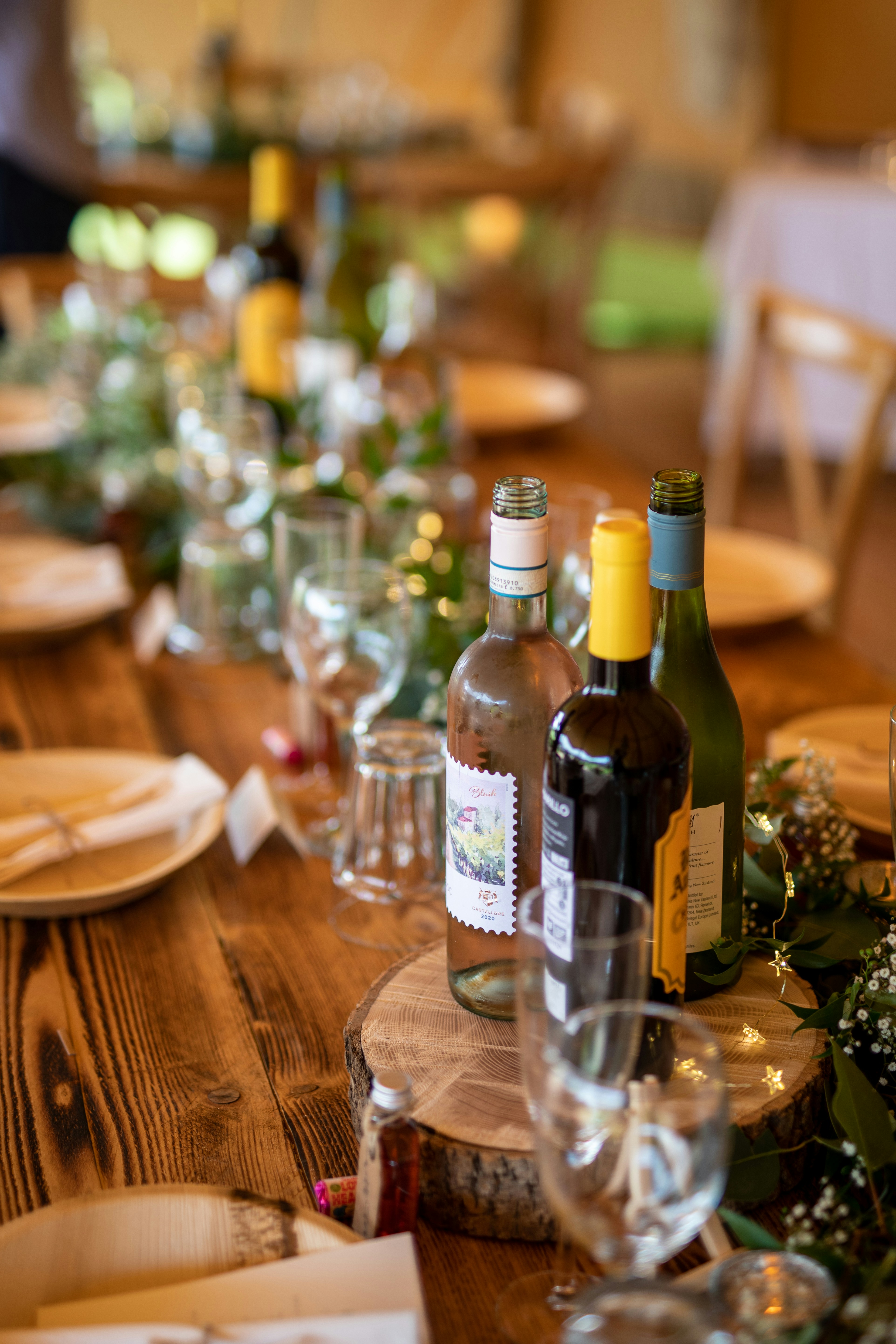 a wooden table topped with bottles of wine