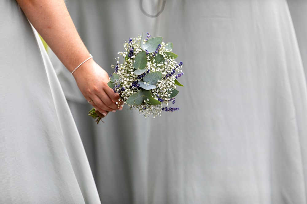 a close up of a person holding a bouquet of flowers