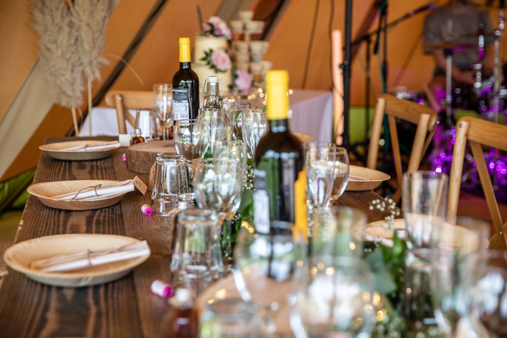 a table set for a party with wine bottles and glasses