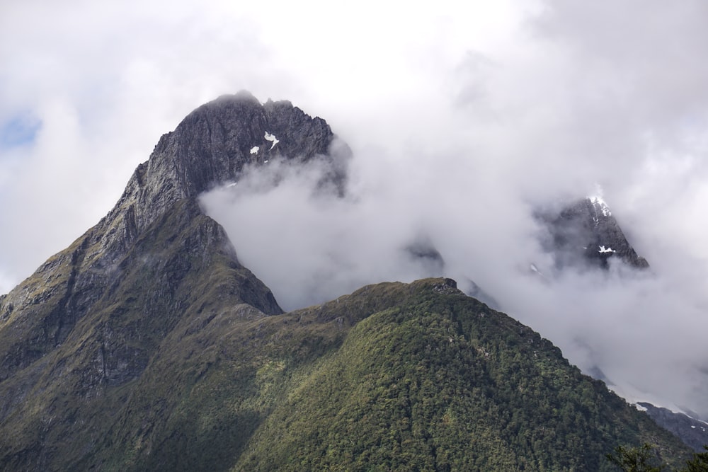 a very tall mountain with some clouds in the air