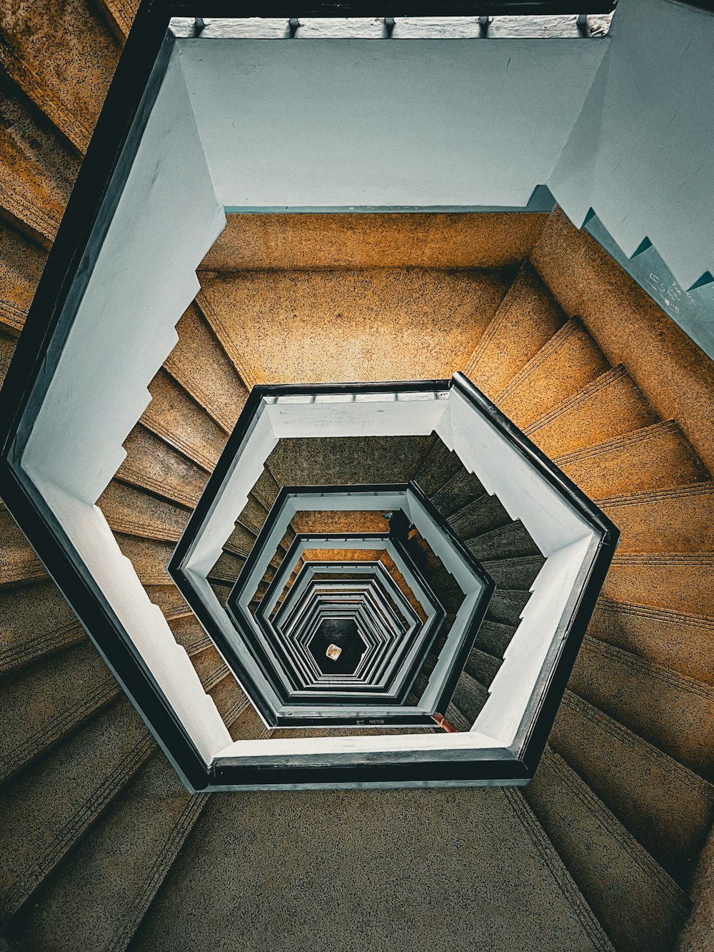 a spiral staircase in a building with a skylight