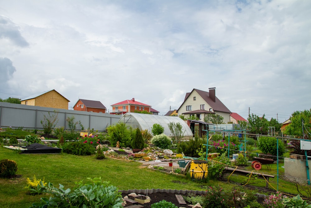 um quintal com muitas plantas e uma casa ao fundo