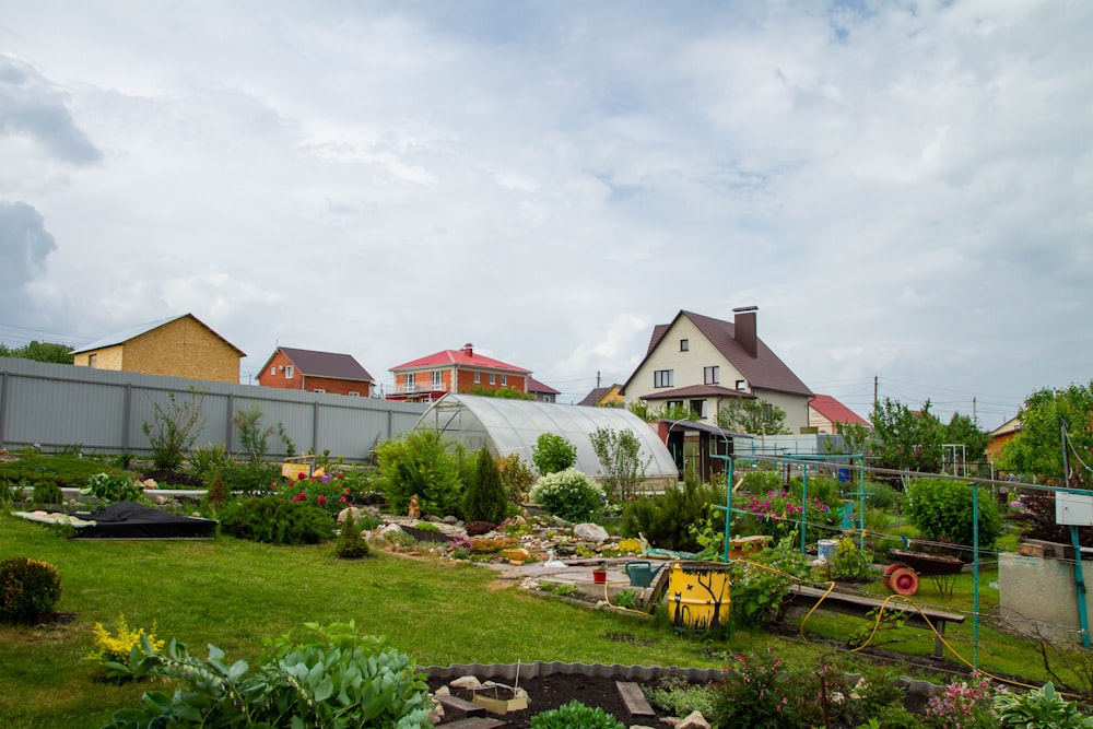 a yard with a lot of plants and a house in the background