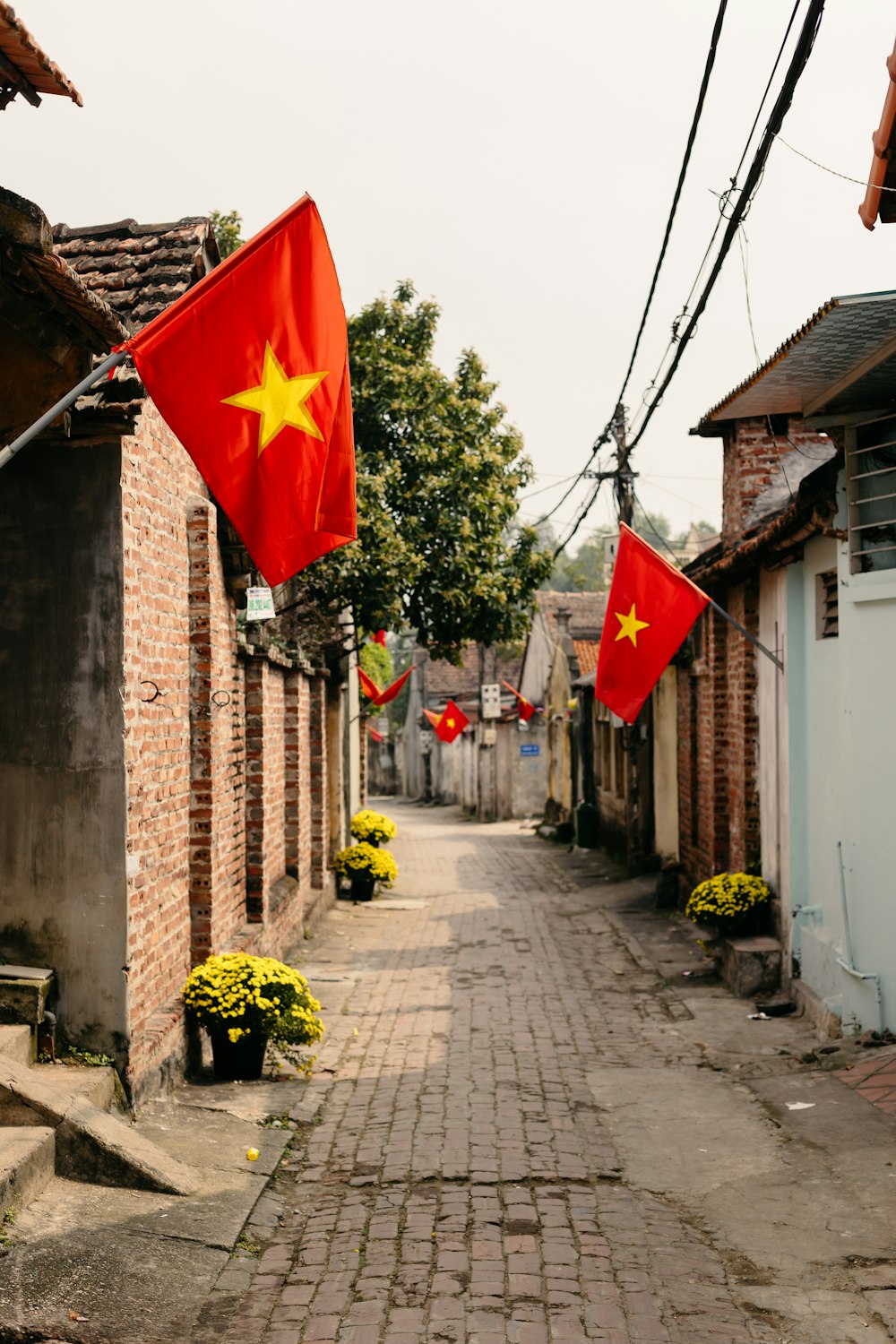 a cobblestone street with a red and yellow flag