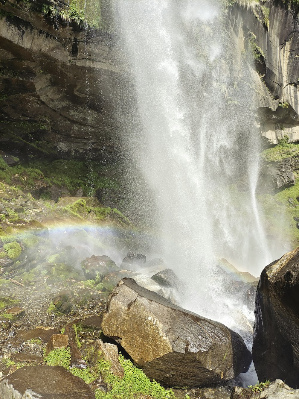 uma cachoeira com um arco-íris no meio dela