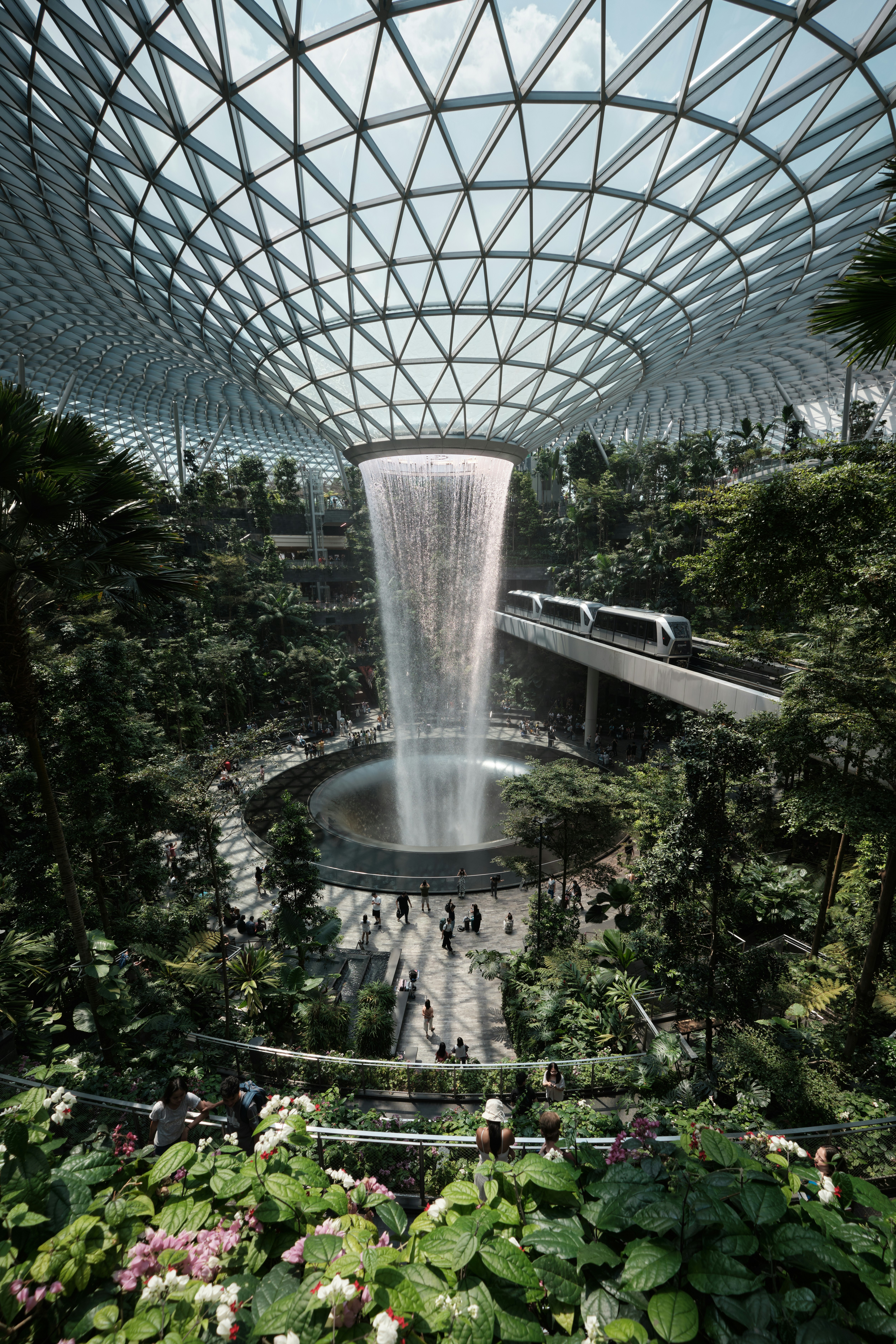 a waterfall in the middle of a tropical garden