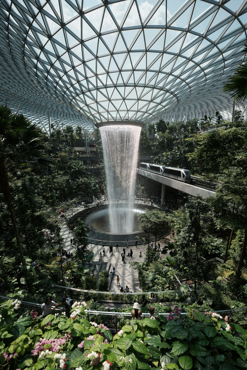 a waterfall in the middle of a tropical garden