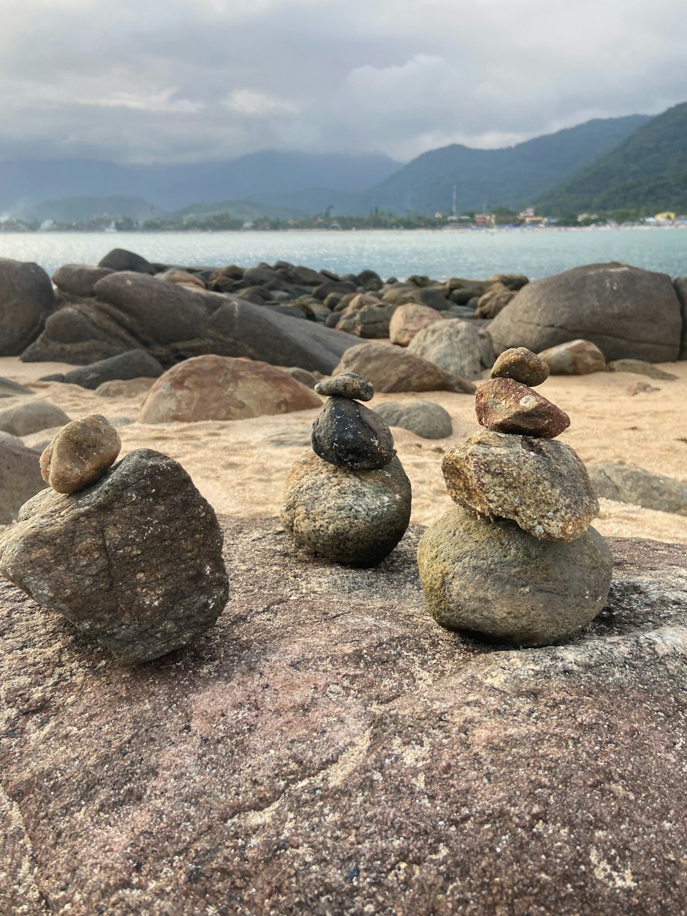 três pedras empilhadas umas sobre as outras em uma praia