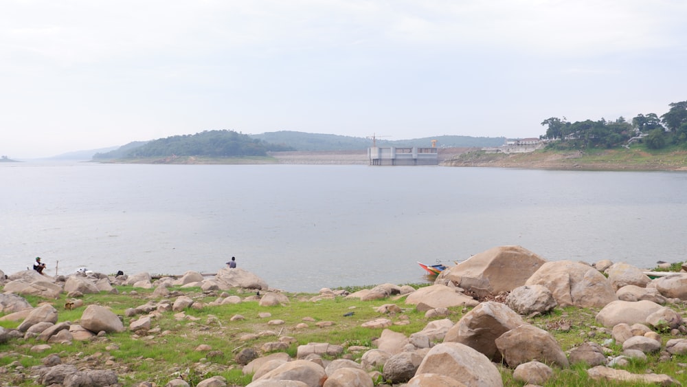 a large body of water surrounded by rocks and grass