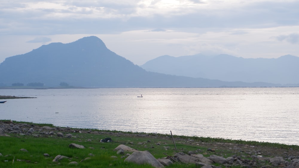 a large body of water with mountains in the background