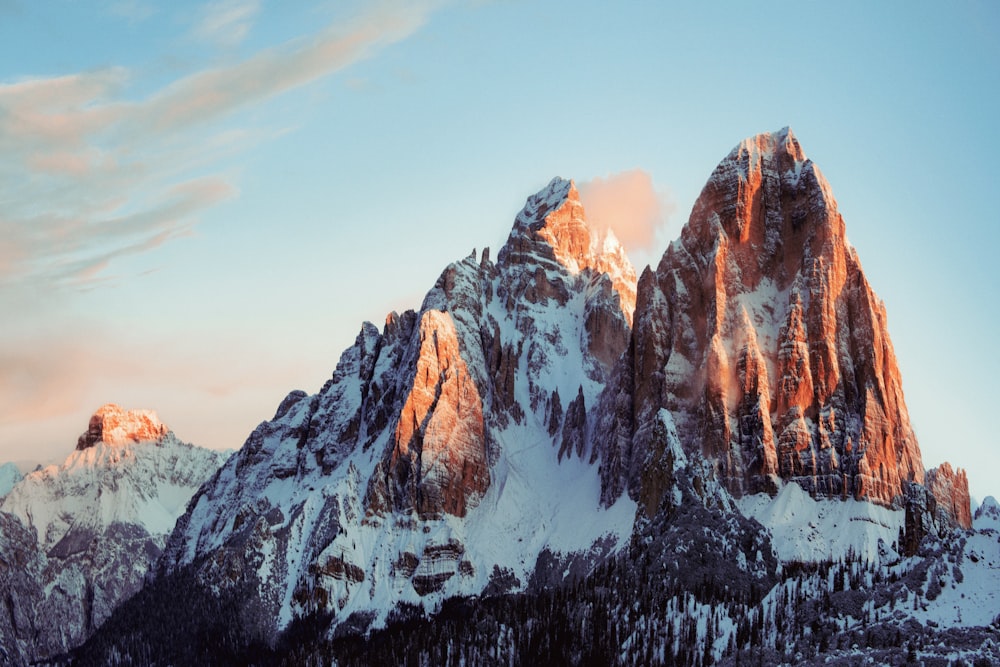 a mountain range covered in snow under a blue sky