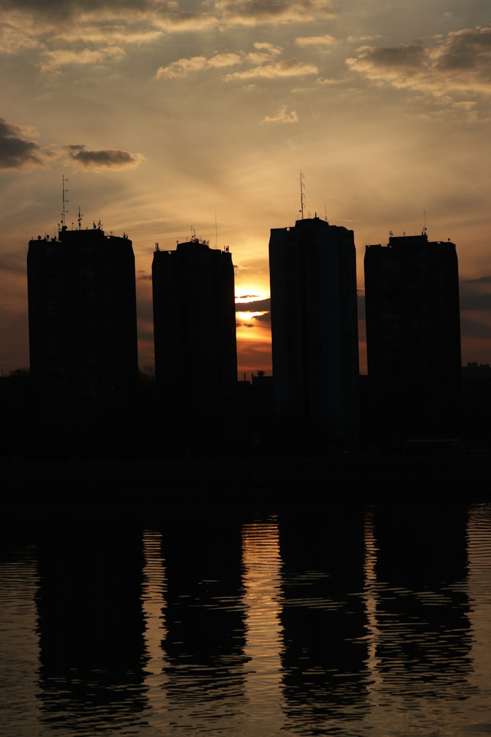 the sun is setting behind some tall buildings