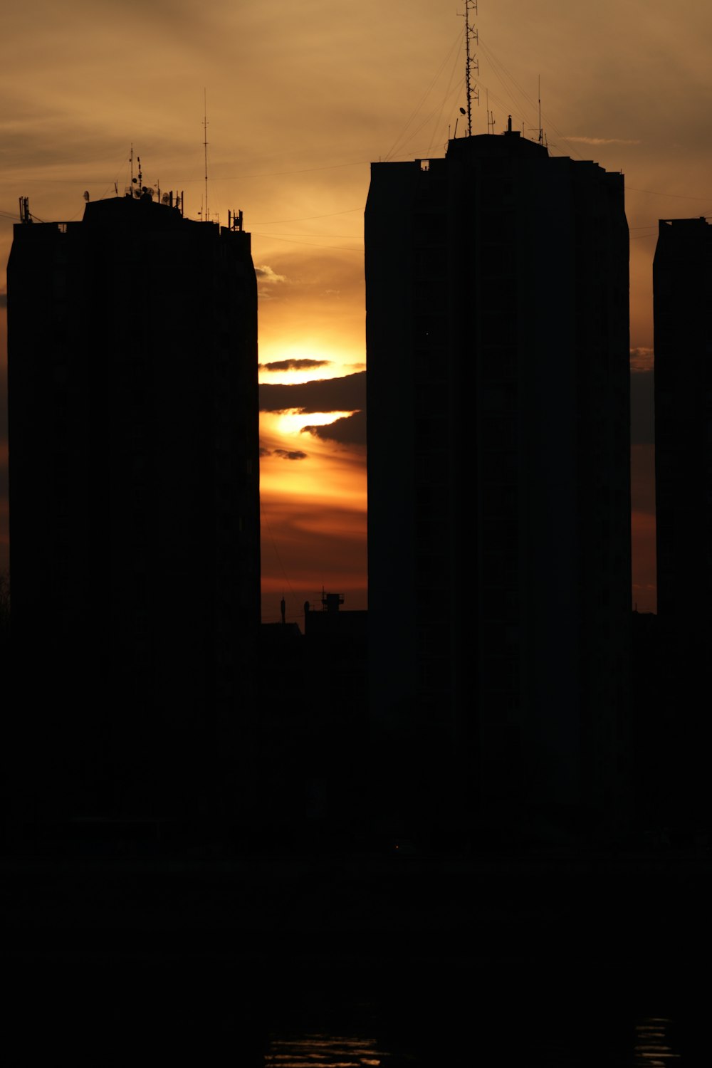 the sun is setting behind some tall buildings