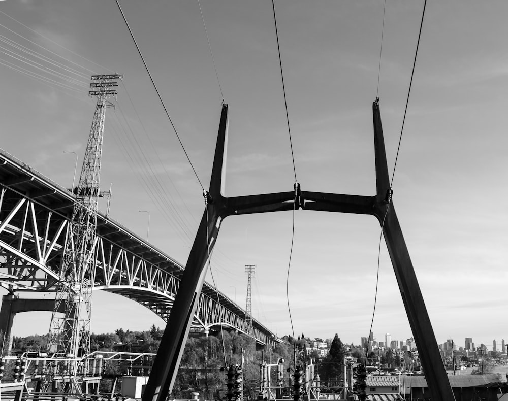 a black and white photo of power lines and a bridge