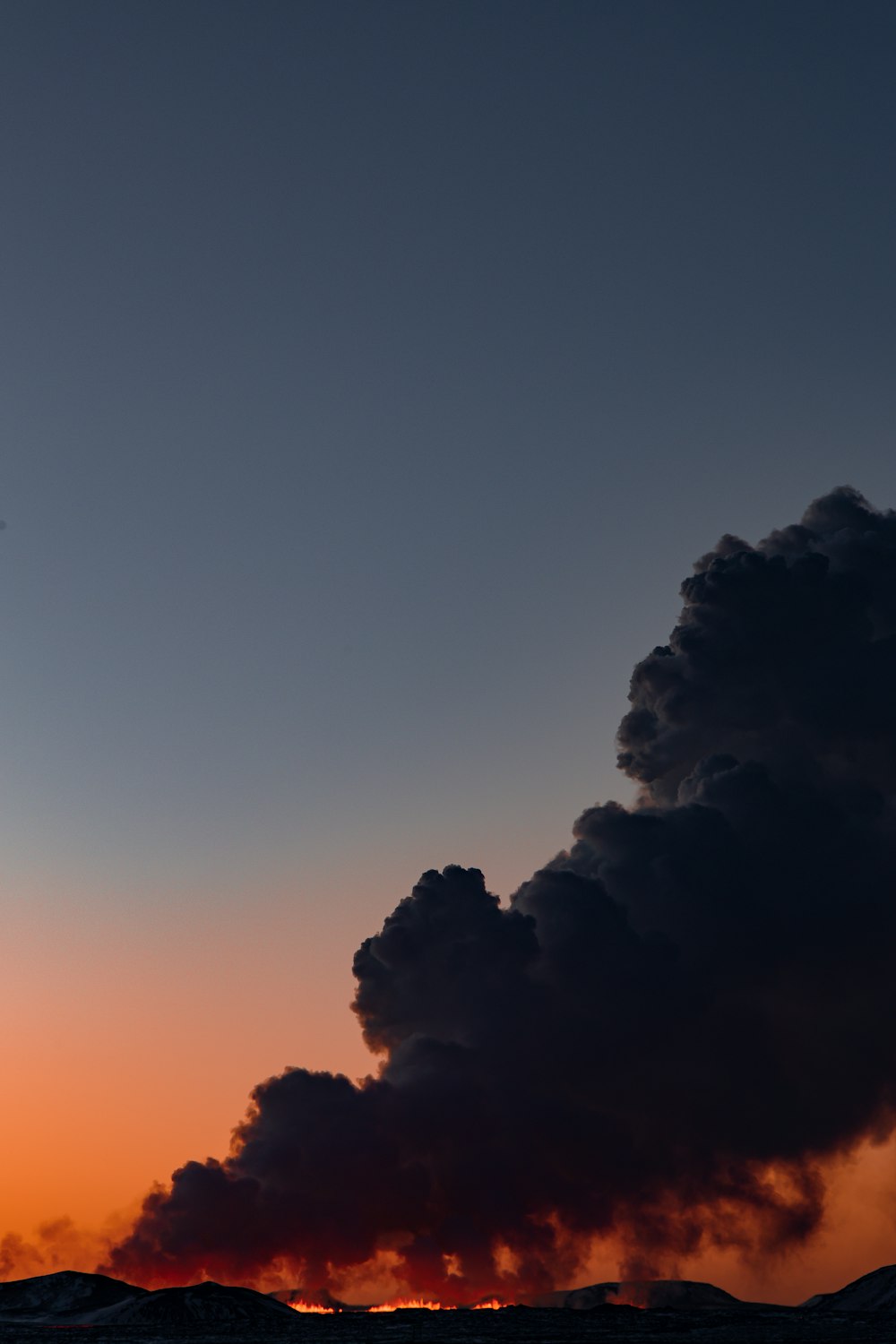 a plane flying in the sky with a lot of smoke coming out of it