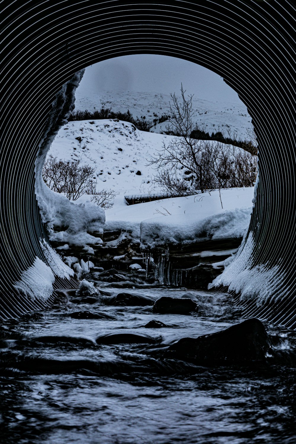 a river running through a tunnel in the snow