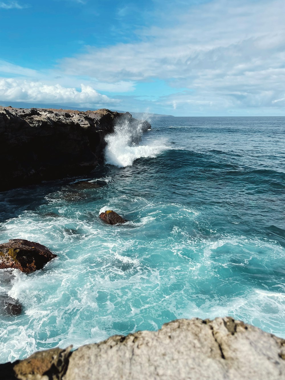 a large body of water next to a rocky shore