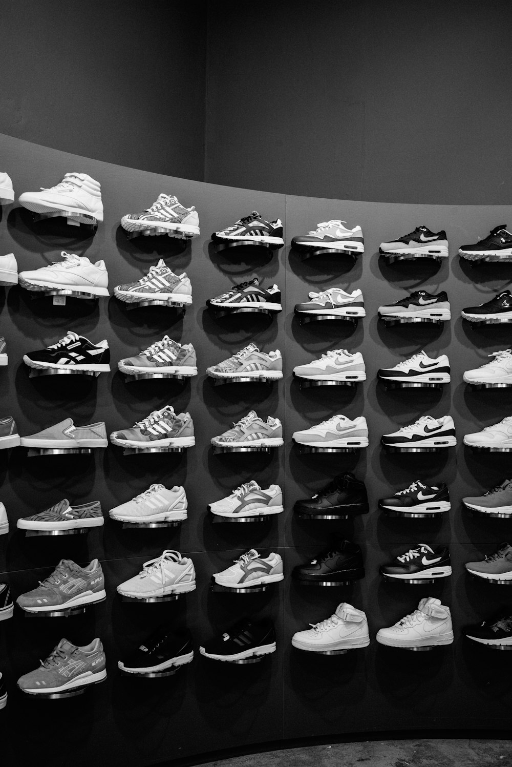 a large display of tennis shoes in a black and white photo
