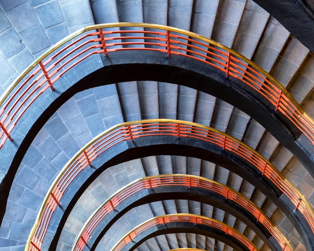 a spiral staircase with red railings in a building