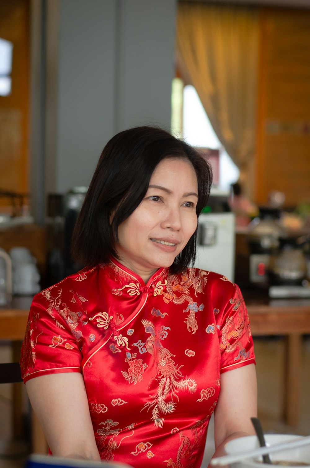 a woman in a red dress sitting at a table