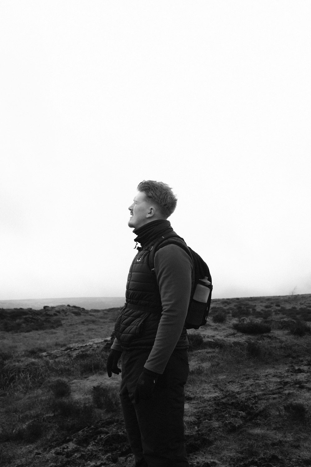 a man with a backpack standing in a field