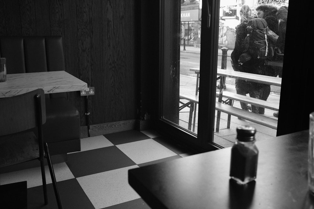 a black and white photo of a man walking into a restaurant