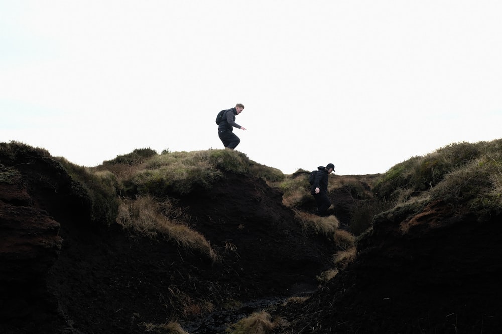 Un hombre de pie en la cima de una exuberante ladera verde