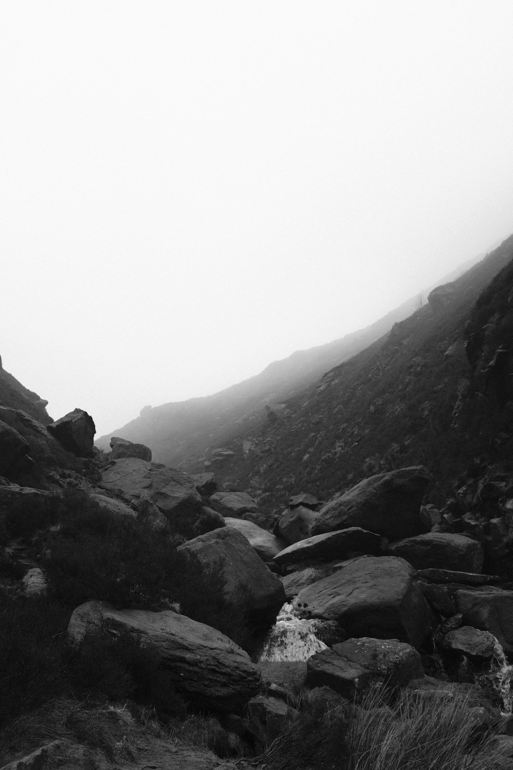 a black and white photo of a mountain stream