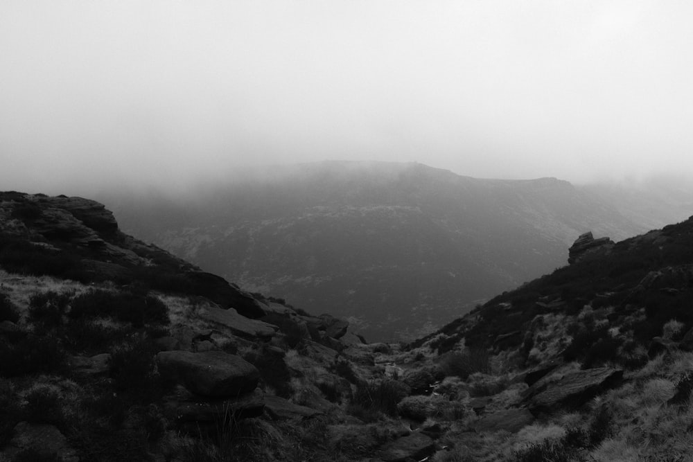 Une photo en noir et blanc d’une montagne brumeuse