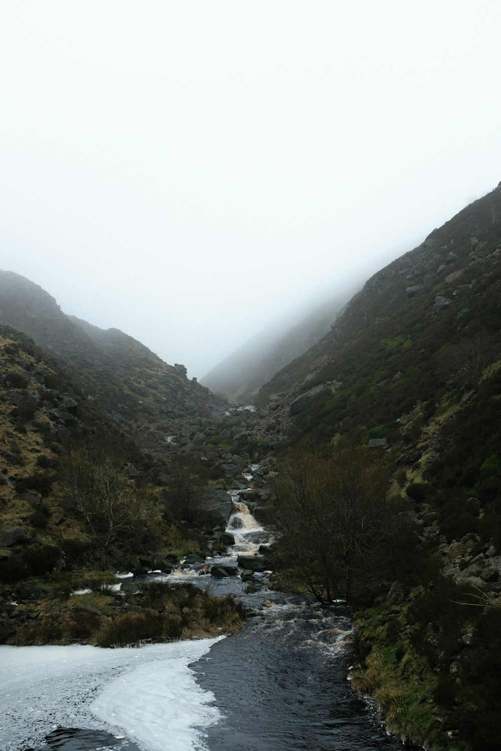 a river running through a lush green hillside